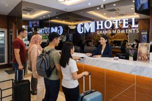 a group of people standing around a counter in a store at GM Grand Moments Bandar Sunway in Petaling Jaya