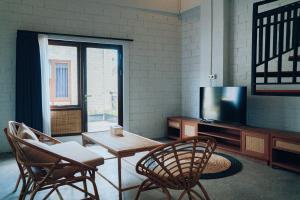 a living room with a table and chairs and a tv at Samada Work Life Canggu in Canggu