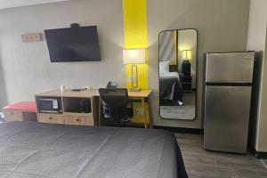 a hotel room with a bed and a mirror at Super 8 by Wyndham Hobbs in Hobbs