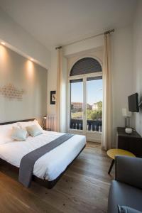 een slaapkamer met een groot bed en een groot raam bij 7Florence in Florence