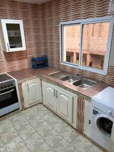a kitchen with a sink and a window at Room 18 in Brusubi