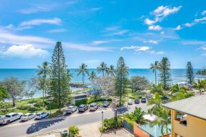 an aerial view of a parking lot with palm trees and the ocean at Coral Sands 503 in Bargara