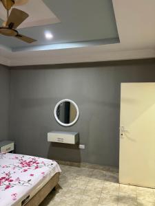 a bedroom with a bed and a mirror on the wall at Room 18 in Brusubi