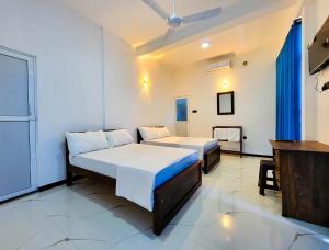 a hotel room with two beds and a television at Cloud View Family Villa in Kandy