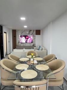 a living room with a glass table and chairs at Pimentel Casa in Chiclayo