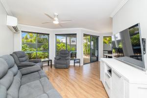 a living room with a couch and chairs and a flat screen tv at Grange Resort Hervey Bay in Hervey Bay