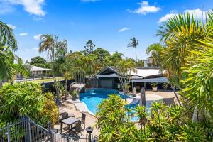 an image of a resort with a swimming pool and palm trees at Grange Resort Hervey Bay in Hervey Bay