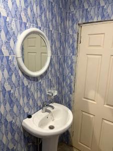 a bathroom with a sink and a mirror at Room 18 in Brusubi +4 photos