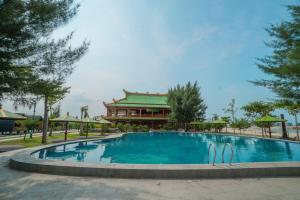 a large swimming pool with a building in the background at PULAU LIMA Resort in Serang