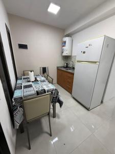 a kitchen with a table and a white refrigerator at Temporario J & B in Paso de los Libres +9 photos