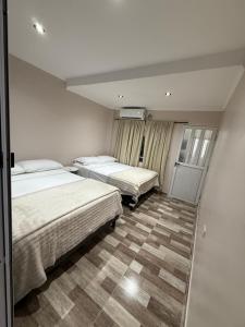 two beds in a hotel room with a room with two at Temporario J & B in Paso de los Libres
