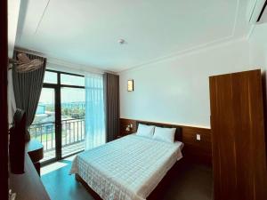 a bedroom with a bed and a large window at Thành Trung Hotel Nghệ An in Vinh +12 photos
