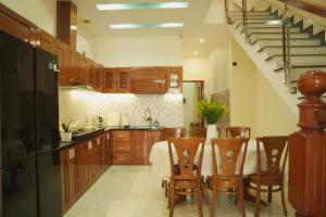 a kitchen with a table and chairs and a staircase at Jasmine Homestay in Danang