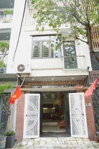 a building with two white doors and flags in front of it at Jasmine Homestay in Danang