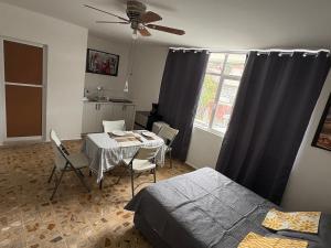a bedroom with a table and a bed and a kitchen at Departamento Estudio C3 Centrico La Casona in Xalapa