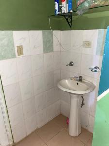 a bathroom with a sink and a white tiled wall at La casa de ito in La Chorrera +18 photos