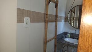 a bathroom with a sink and a mirror at Casa de hospedes em condominio com lazer in Búzios +79 photos