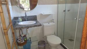 a bathroom with a toilet and a sink and a shower at Casa de hospedes em condominio com lazer in Búzios