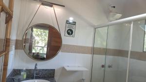 a bathroom with a sink and a mirror at Casa de hospedes em condominio com lazer in Búzios