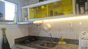 a kitchen counter with a sink and a cupboard at Casa de hospedes em condominio com lazer in Búzios