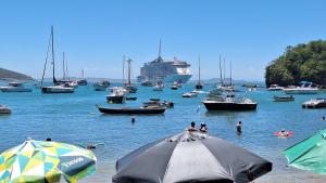 a group of boats in the water with a cruise ship at Casa de hospedes em condominio com lazer in Búzios
