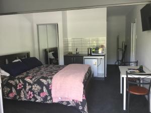a bedroom with a bed and a desk and a kitchen at Giulia Guests Rooms in Beechmont
