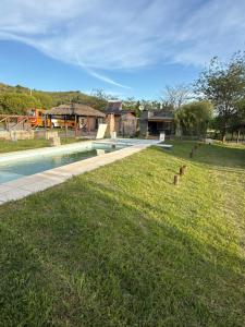 a yard with a swimming pool and a house at Potrero Village Suites Refugios Serranos in Potrero de Garay