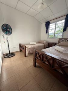a room with two beds and a fan in it at Potrero Village Suites Refugios Serranos in Potrero de Garay +30 photos