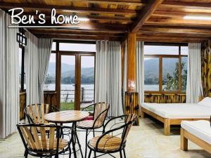 a bedroom with a bed and chairs and a table at Bon Ben Homestay in Hòa Bình