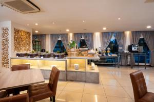 a restaurant with tables and chairs and a kitchen at One Pacific Hotel and Serviced Apartments in George Town