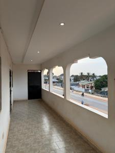 an empty hallway with windows with a view of a beach at Room 17 in Brufut