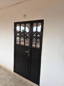 a black door in a white wall at Room 17 in Brufut