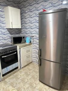 a kitchen with a stainless steel refrigerator and a microwave at Room 17 in Brufut
