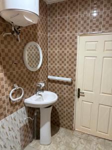 a bathroom with a white sink and a mirror at Room 17 in Brufut +7 photos