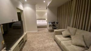 a living room with a couch and a flat screen tv at نسيم الحرم in Ash Shishah
