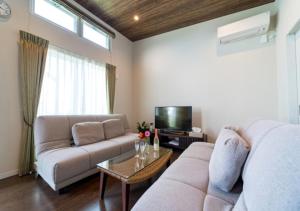 a living room with a couch and a tv at BEVERLY HILLS VILLA Miyakojima Resort in Miyako-jima +56 photos