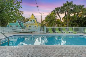 a house with a swimming pool in front of a house at Anchor Inn & Cottages in Sanibel