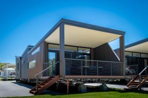 a modern house with large glass windows and stairs at BIG4 Ulladulla Beachside Holiday Park in Ulladulla