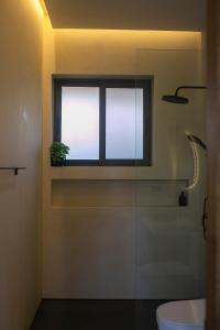 a bathroom with a toilet and a window with a plant at NOBELLA Villa, Luxury Boutique Hotel in Ko Phangan +17 photos