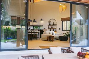 a living room and dining room with sliding glass doors at NOBELLA Villa, Luxury Boutique Hotel in Ko Phangan