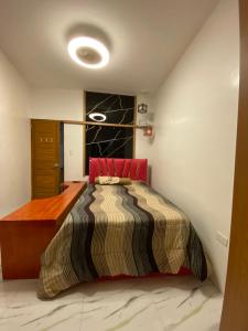 a bedroom with a bed with a red head board at Casa Sandrine Resort in Malolos