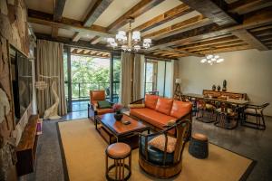 a living room with a couch and a table at ZhangJiaJie Peak&Creek Resort-Free Infinity Pool-Near the Ticket Gate-Stream Exploration Experience in Zhangjiajie
