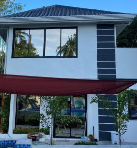 a house with a red curtain in front of it at Casa Sandrine Resort in Malolos