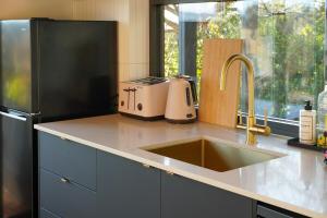 a kitchen with a sink and a refrigerator at Wren House Victor Harbor in Victor Harbor