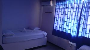 ein Zimmer mit zwei Betten und einem großen Fenster in der Unterkunft Hotel La Séptima in Neiva + 8 Fotos