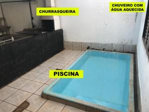 a hot tub in a room with two yellow labels at Farofa House Àrea de Lazer in Ribeirão Preto