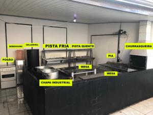 a kitchen with yellow signs on a counter in a kitchen at Farofa House Àrea de Lazer in Ribeirão Preto
