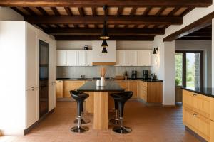 a kitchen with a table and black counter chairs at VILLA ADELE - Ville Carborello in Crispiero