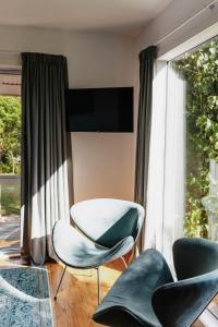a living room with two chairs and a table at Studio 531 in Coromandel Town