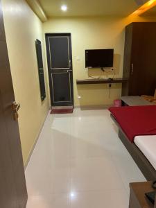 a room with a television and a white floor at Hotel Swagat Residency in Panhāla +2 photos